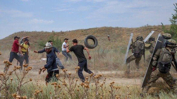 Военнослужащие отражают нападение условно радикально настроенных молодых людей, которые кидают в военных автомобильные покрышки. [Павел Михеев]