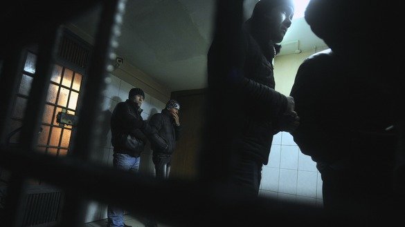 Қўлга олинган ўзбекистонлик ноқонуний мигрантлар Қозон темир йўл бекатидаги полиция ҳибсхонасининг панжаралари ортида, Москва, 24 январ, 2012 йил. (Андрей Смирнов/АФП)