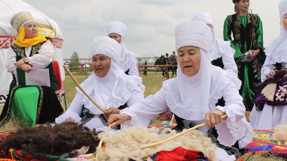 Женщины в казахских национальных костюмах прядут шерсть и поют. [Айдар Ашимов]