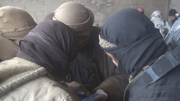 13 декабрь куни ИД томонидан Телеграм тармоғида чоп этилган суратда Сурияда смартфонга тикилиб турган бир гуруҳ жангарилар тасвирланган. (Файл)