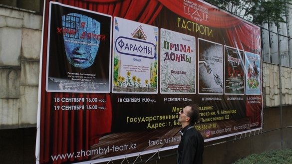 «Уйга қайтишни истайман» спектаклининг эълонини кўздан кечираётган ўткинчилардан бири, 18 сентябрь, Бишкек. (Айдар Ашимов)