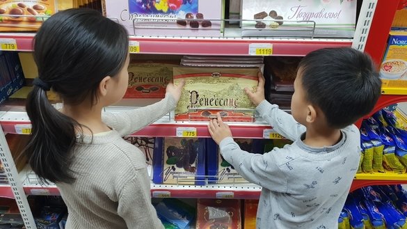 Олмаота супермаркетида «Рахат» ширинликларини танлаётган болалар, 28 март. (Канат Алтинбаев)
