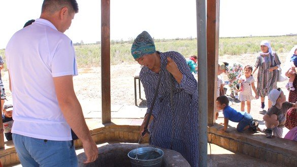 Женщина достает воду из священного колодца рядом с мавзолеем Арыстанбаба. Туркестанская область, 7 июня. [Айдар Ашимов]