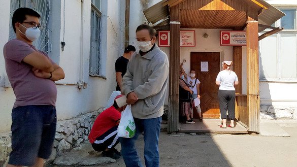 В тревожном ожидании родственники больных стоят у дверей больницы. Они приносят еду и лекарства своим родным. Кара-Балты, 11 июля. [Максат Осмоналиев]