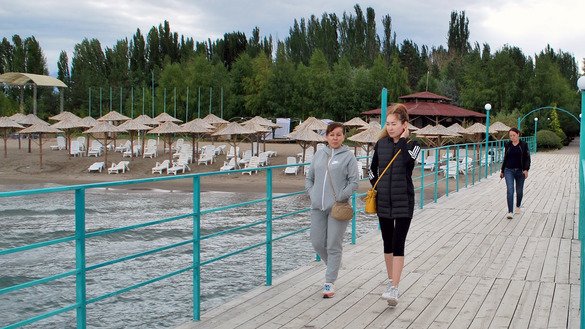 Отдыхающие прогуливаются по пирсу курорта «Марко Поло». По словам менеджера отеля Евгения, туристов из России или Казахстана в этом году нет. «Но мы работаем в сфере внутреннего туризма. Сейчас здесь 70 гостей. В прошлом году в это время их было 520», — рассказал он. Боз-Бешик, Иссык-Кульская область, 26 июля. [Максат Осмоналиев]