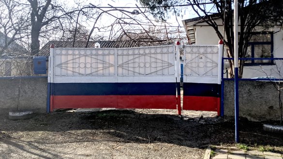После аннексии Крыма Россией некоторые жители начали красить заборы в российский триколор. Ворота с цветами российского флага. Поселок Кизилташ, 5 марта. [Евгений Гордиенко/«Каравансарай»]