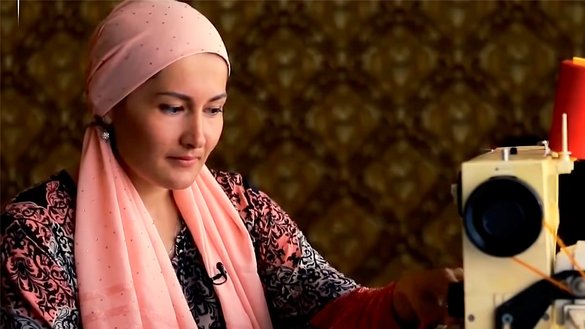 Скриншот из документального фильма о гуманитарной спецоперации «Мехр» на телеканале «Узбекистан 24»: репатриированная узбекская женщина работает на швейной машинке.